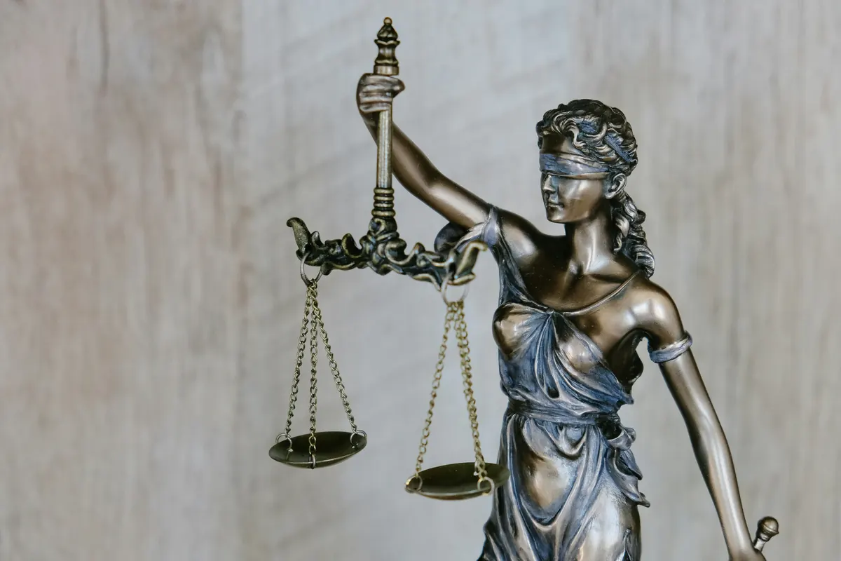 Estátua da Justiça sobre a mesa do escritório Marcondes D'Elia Advocacia